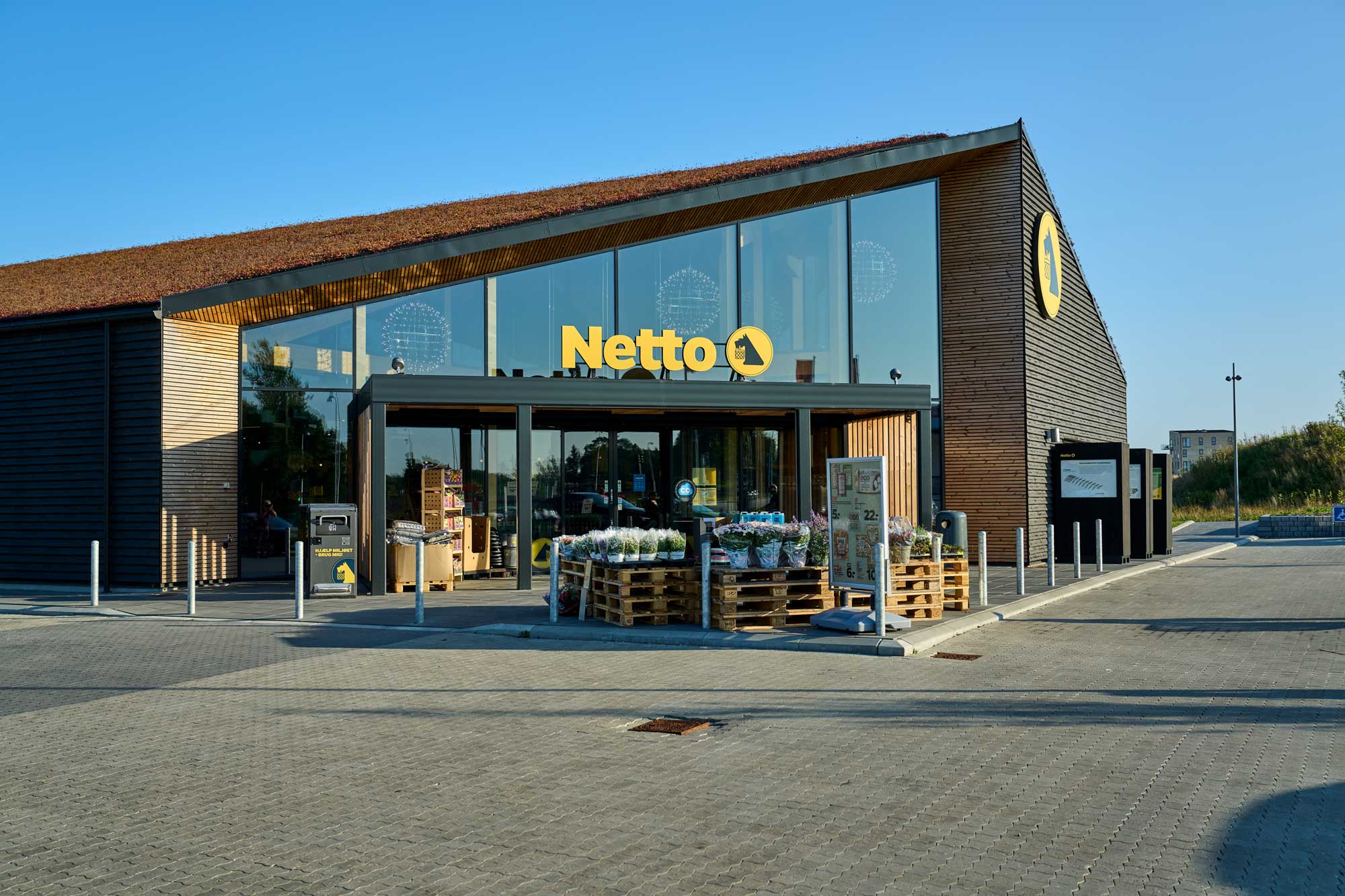 Netto-bygning med sedumtag samt træ- og teglbeklædning.