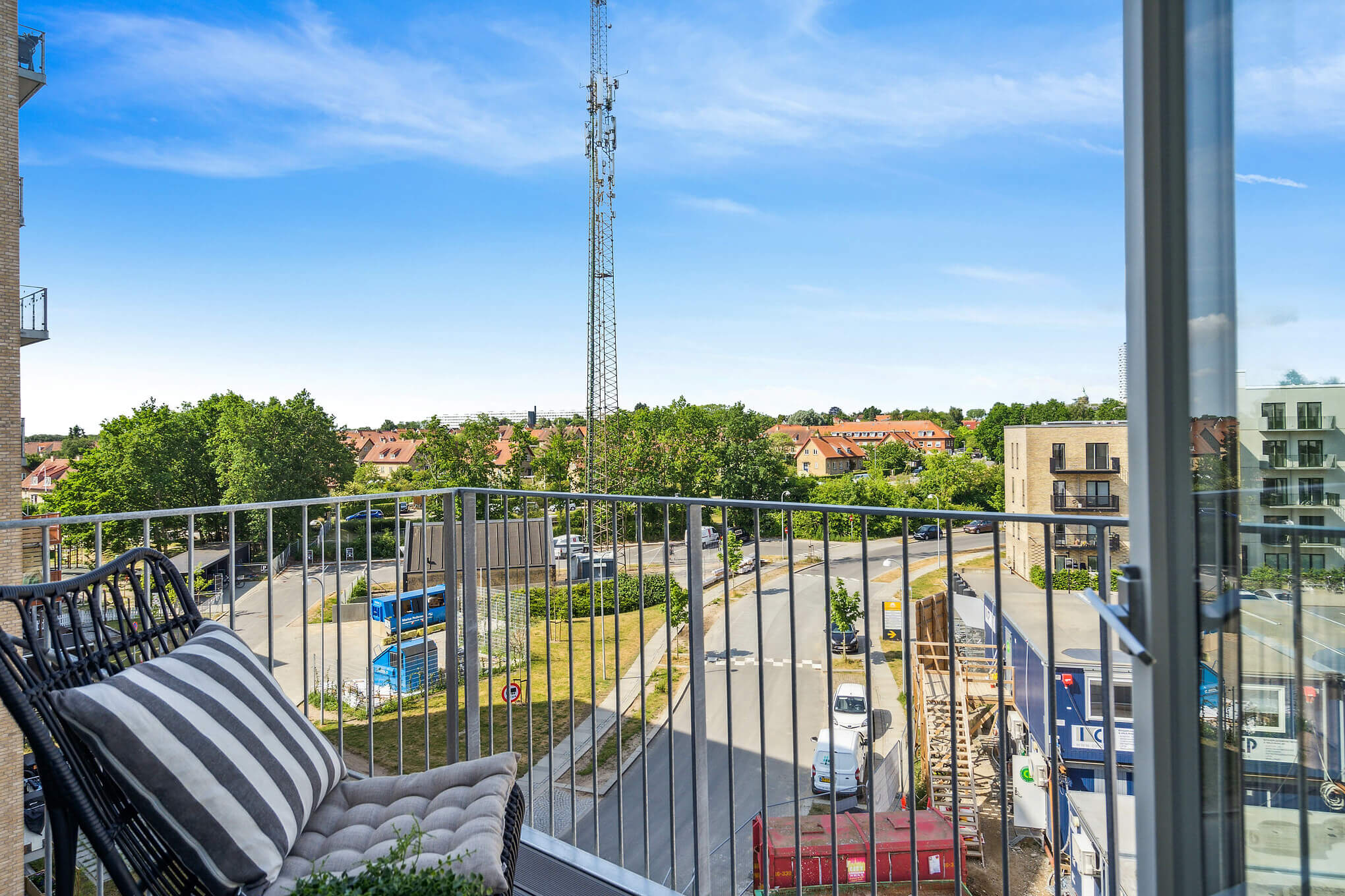 Altan med stol og udsigt til by og vej.